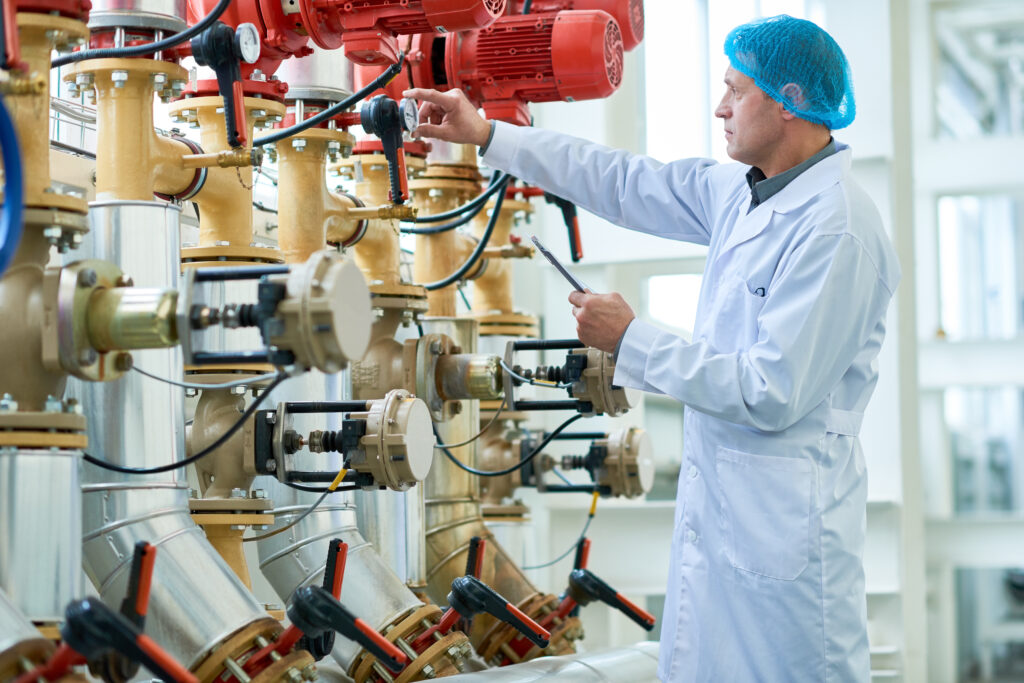 Worker Checking Pipes and valves in Factory