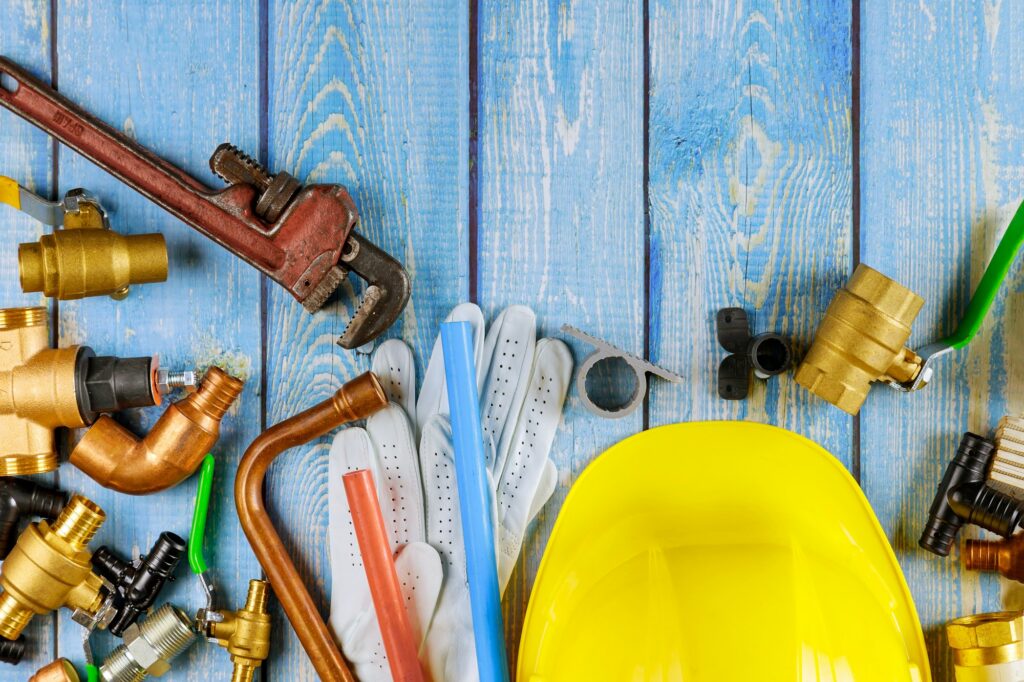 Plumbing tool pipes, fittings on valves wrench work gloves in the water supply